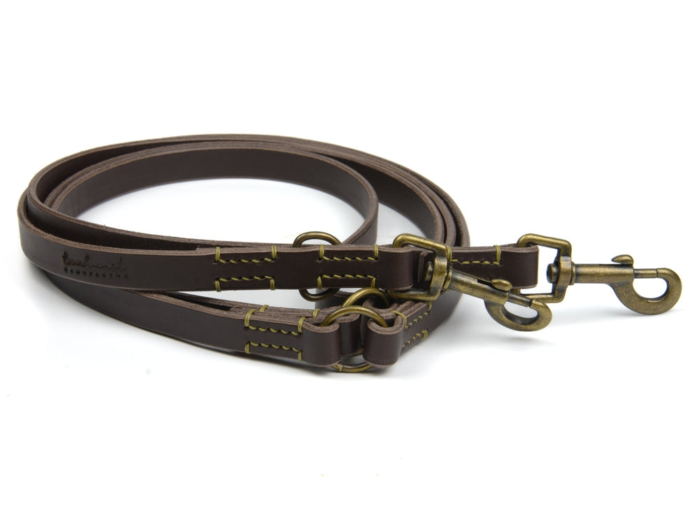 Braune Lederleine Waldgeist mit zwei Karabinern und gelber doppelter Naht, ideal für Hundebesitzer.