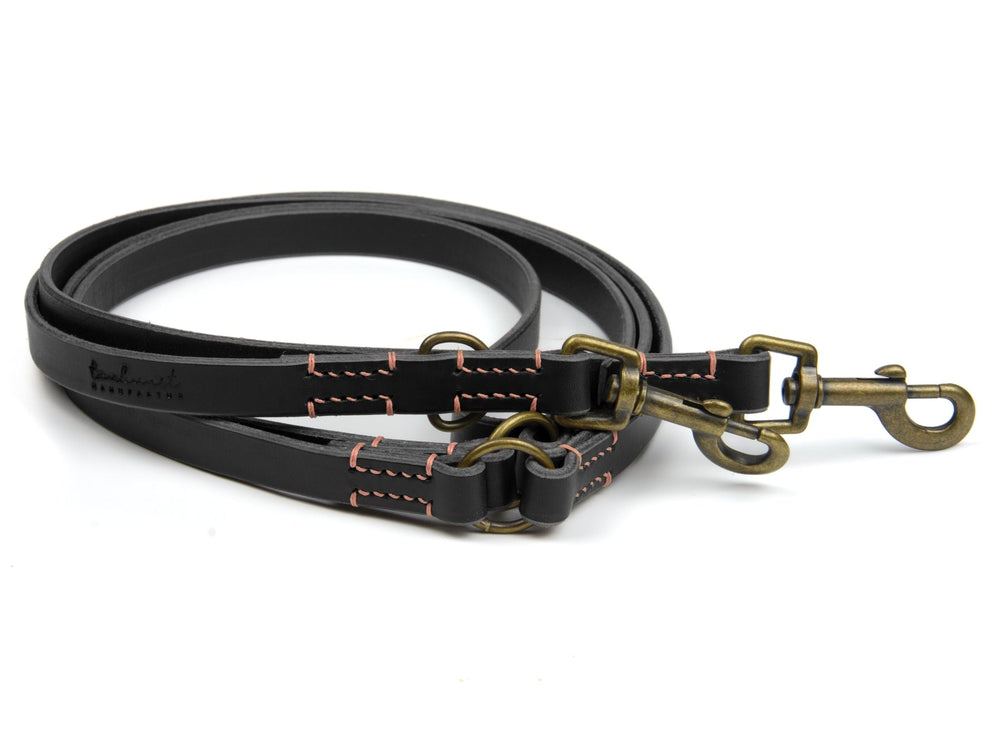 Doppelte Lederleine "Waldgeist" in Schwarz mit roten Nähten und zwei robusten Karabinerhaken für Hunde.