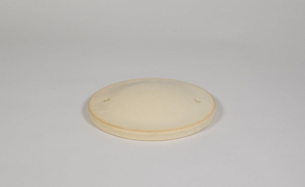 Runde cremefarbene Nisthöhle mit erhöhtem Rand und zwei Löchern, ideal als Ersatzteil für Vogelhäuser.