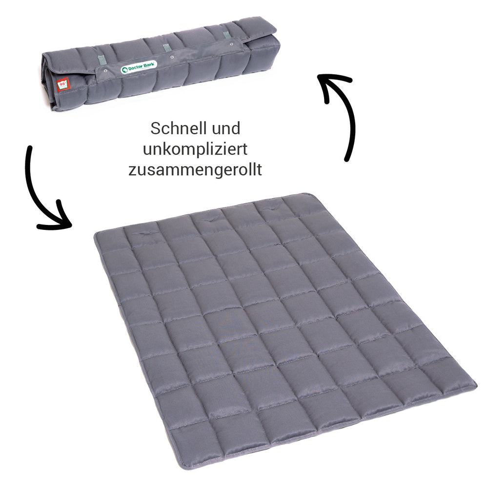 Graue, faltbare Doctor Bark Decke PORTABLE auf flacher Oberfläche ausgebreitet und teilweise gerollt.