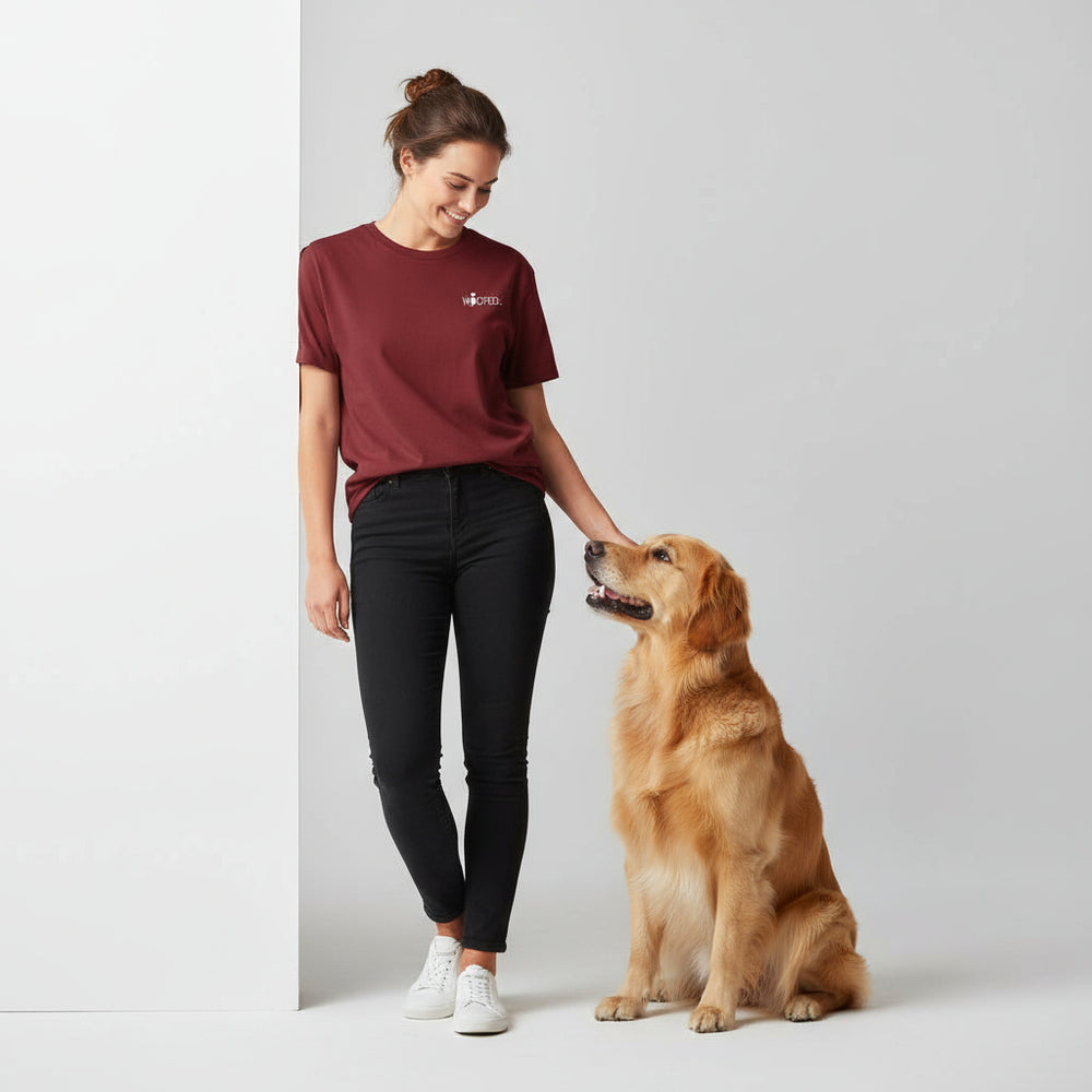 Frau in rotem Unisex-T-Shirt "Life is better with dogs" streichelt ihren golden Retriever im Freien.