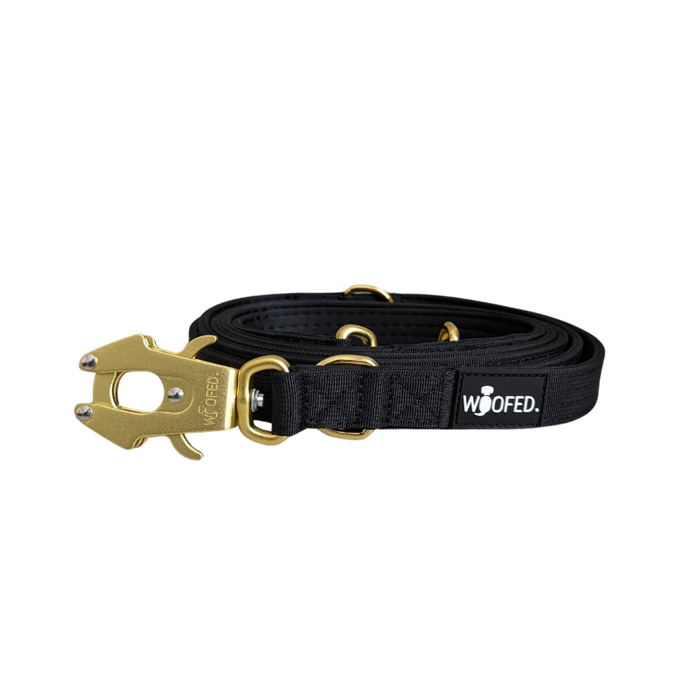 Schwarze Hundeleine aus Nylon mit goldfarbenem Karabinerhaken und WOOFED-Logo-Applikation. Ideal für Spaziergänge.