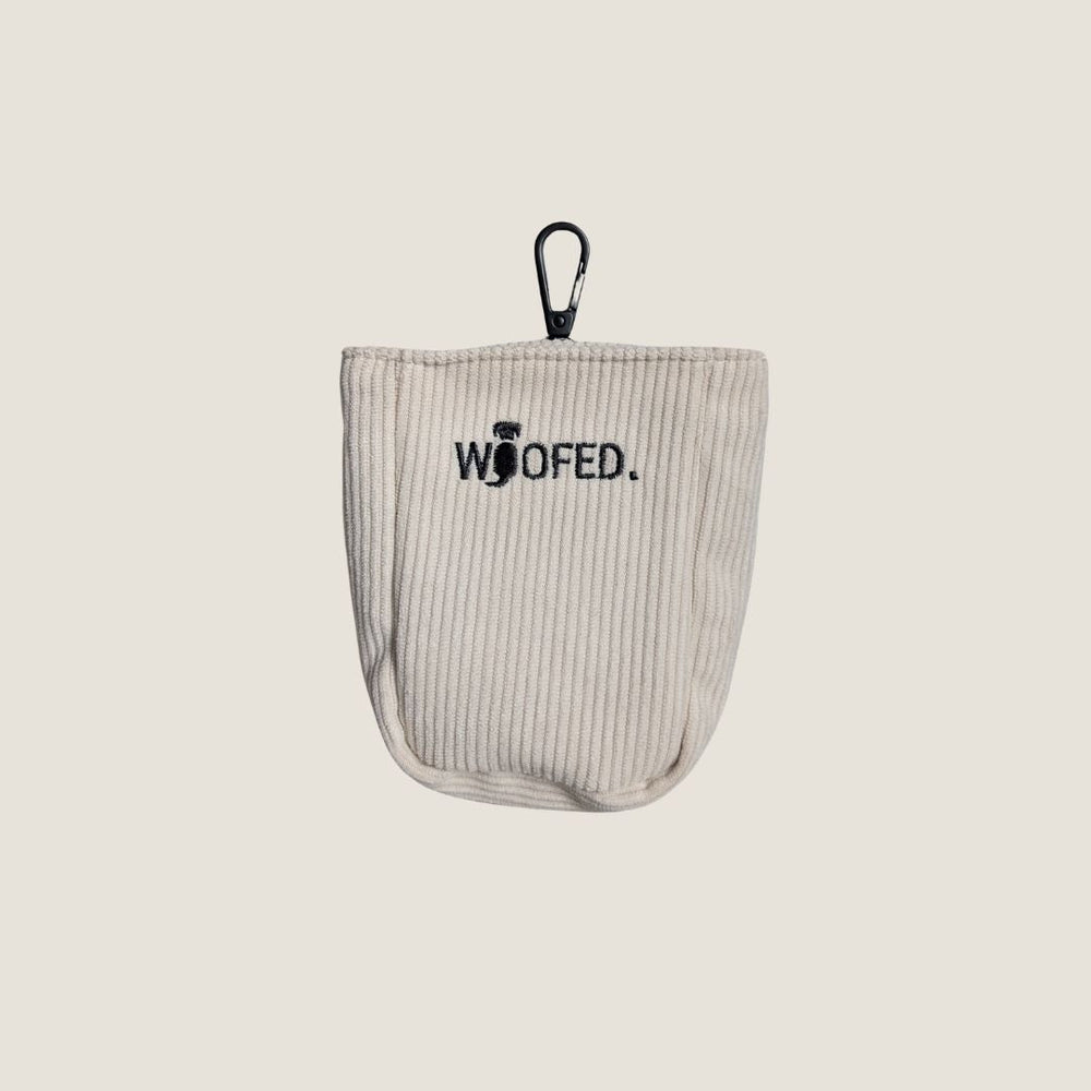 Beige Gassitasche mit WOOFED.-Aufschrift, Clip und strukturiertem Stoff für Hunde-Leckerlis.