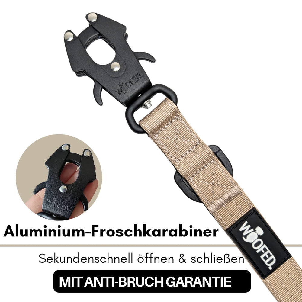 Schwarzer Aluminium-Froschkarabiner mit beige Befestigungsriemen, ideal für sicheres Öffnen und Schließen. Anti-Bruch-Garantie.