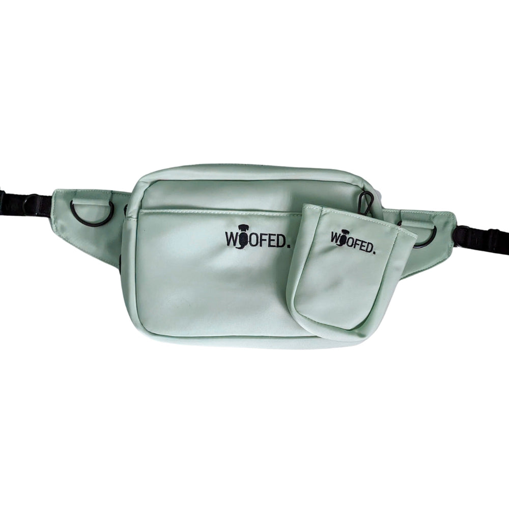 Mintgrüne multifunktionale Gassitasche als Bauchtasche und Schultertasche mit zwei Fächern und "WOOFED." Aufschrift.