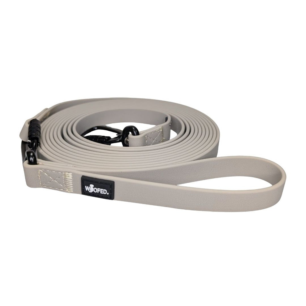 Hundefreundliche Schleppleine WOOFLEX® mit stabilem Karabiner und bequemer Handschlaufe in neutralem Beige-Ton.