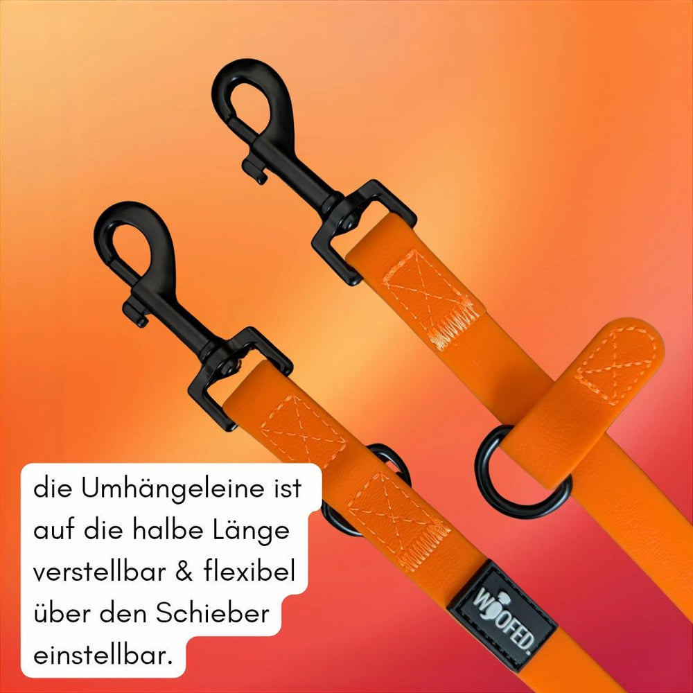 Orangefarbene Umhängeleine WOOFLEX® Classic mit zwei schwarzen Karabinerhaken und verstellbarer Länge im attraktiven Farbhintergrund.