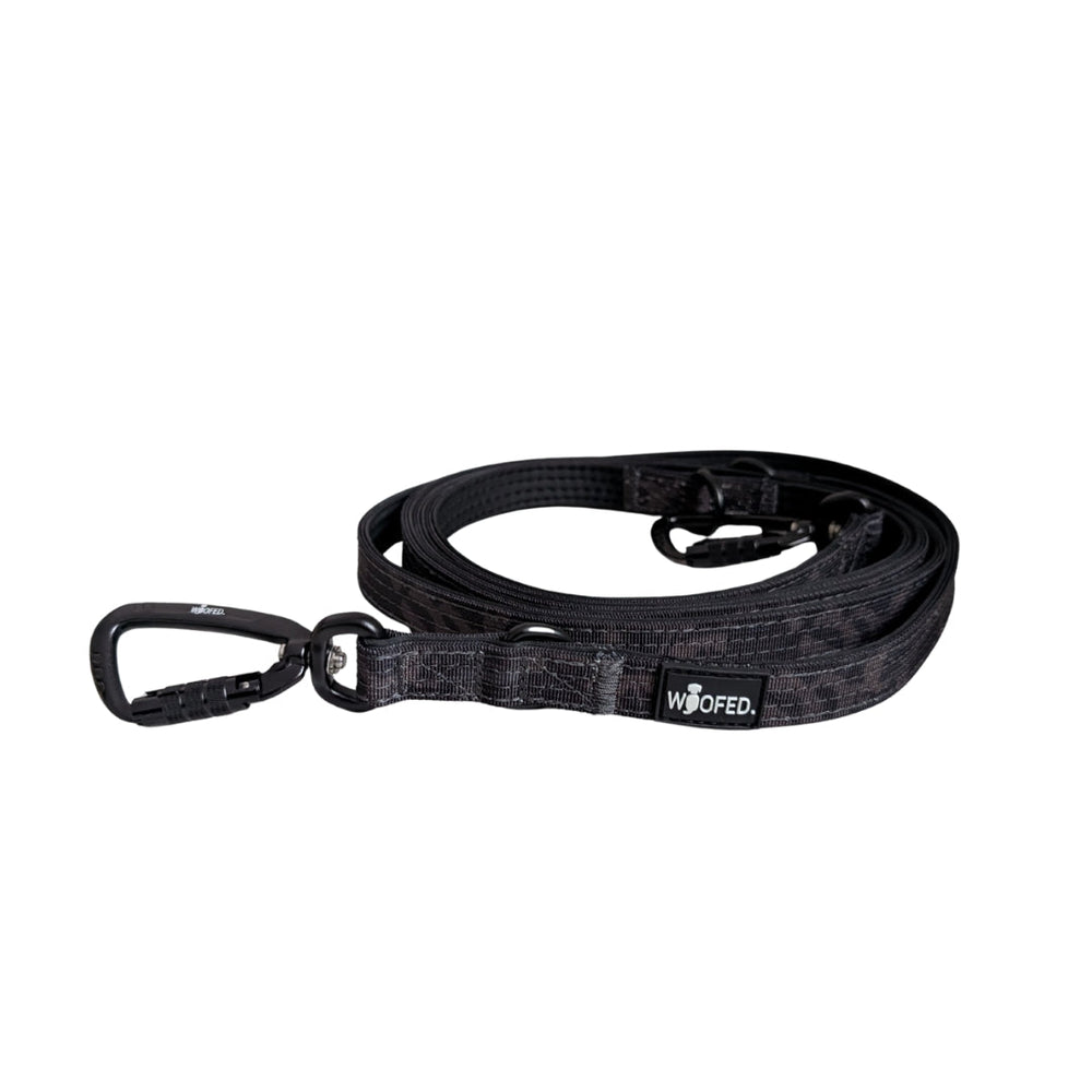 Schwarze Hundeleine aus Nylon mit zwei Karabinern und WOOFED-Logo für optimale Sicherheit und Komfort.