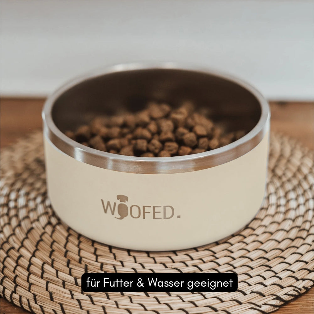 Runder Premium Edelstahlnapf mit cremefarbiger Außenseite und Aufdruck „WOOFED.“, gefüllt mit Hundetrockenfutter.