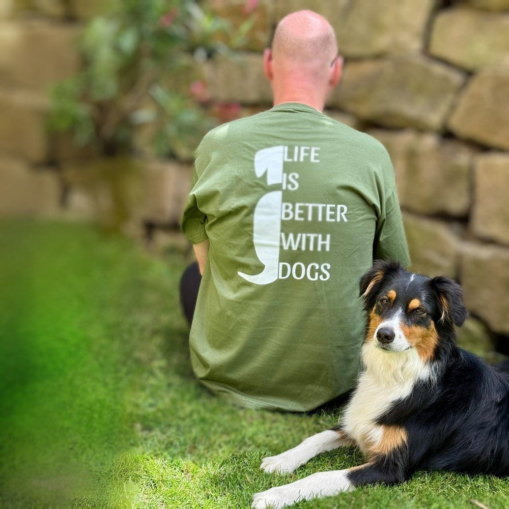 Person mit grünem T-Shirt "LIFE IS BETTER WITH DOGS" sitzt neben ihrem Hund.