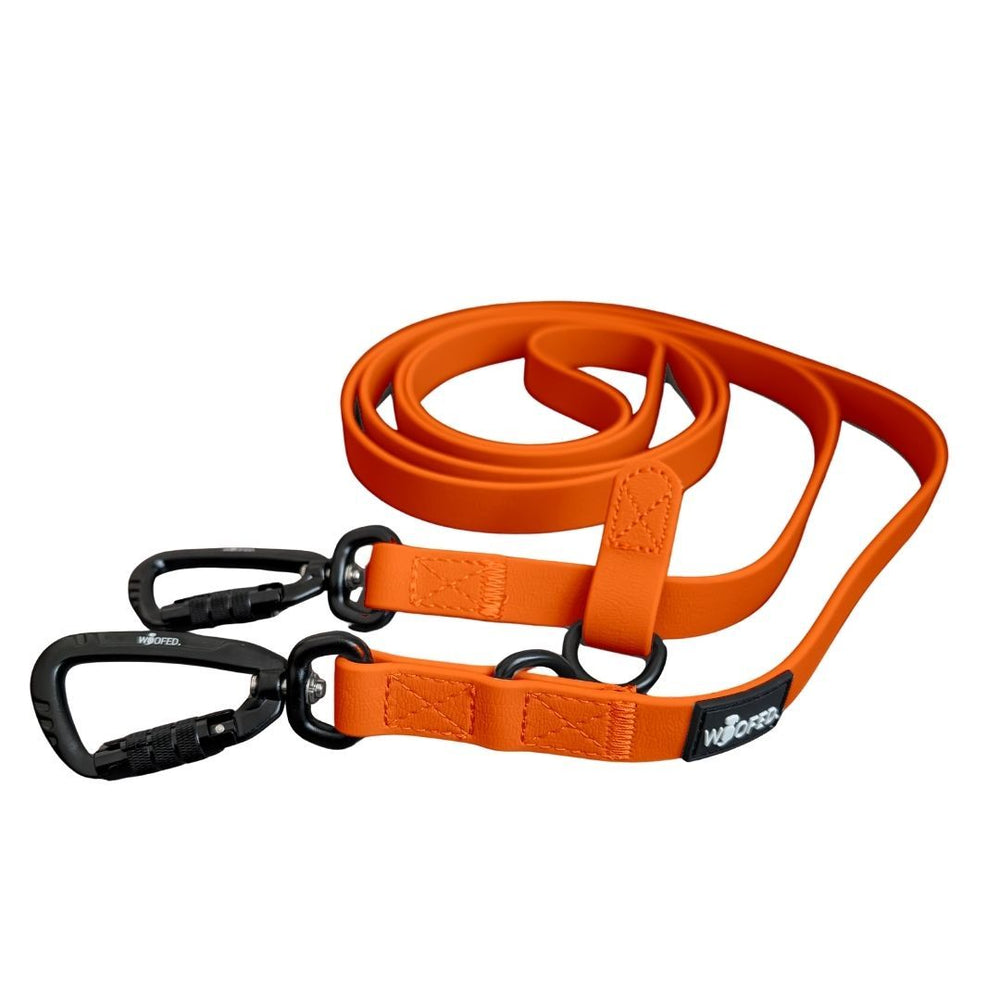 Orange Umhängeleine WOOFLEX® Pro mit zwei Karabinerhaken, flexiblem Material und schlanker Oberfläche für Hunde.