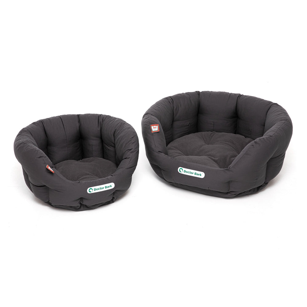 Zwei runde, schwarze, gepolsterte Hundebetten in verschiedenen Größen mit weicher Oberfläche.