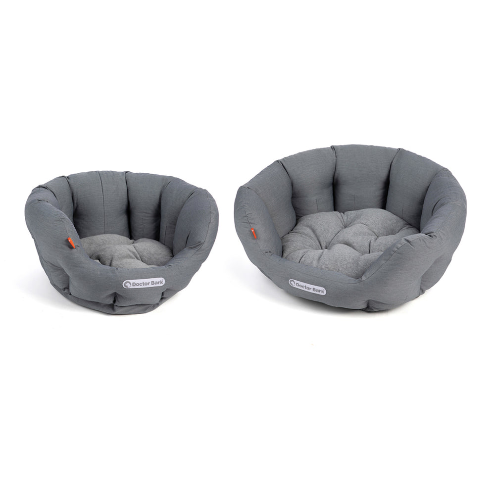 Zwei runde, gepolsterte Hundebetten in Grau mit tufted Design für optimalen Komfort.