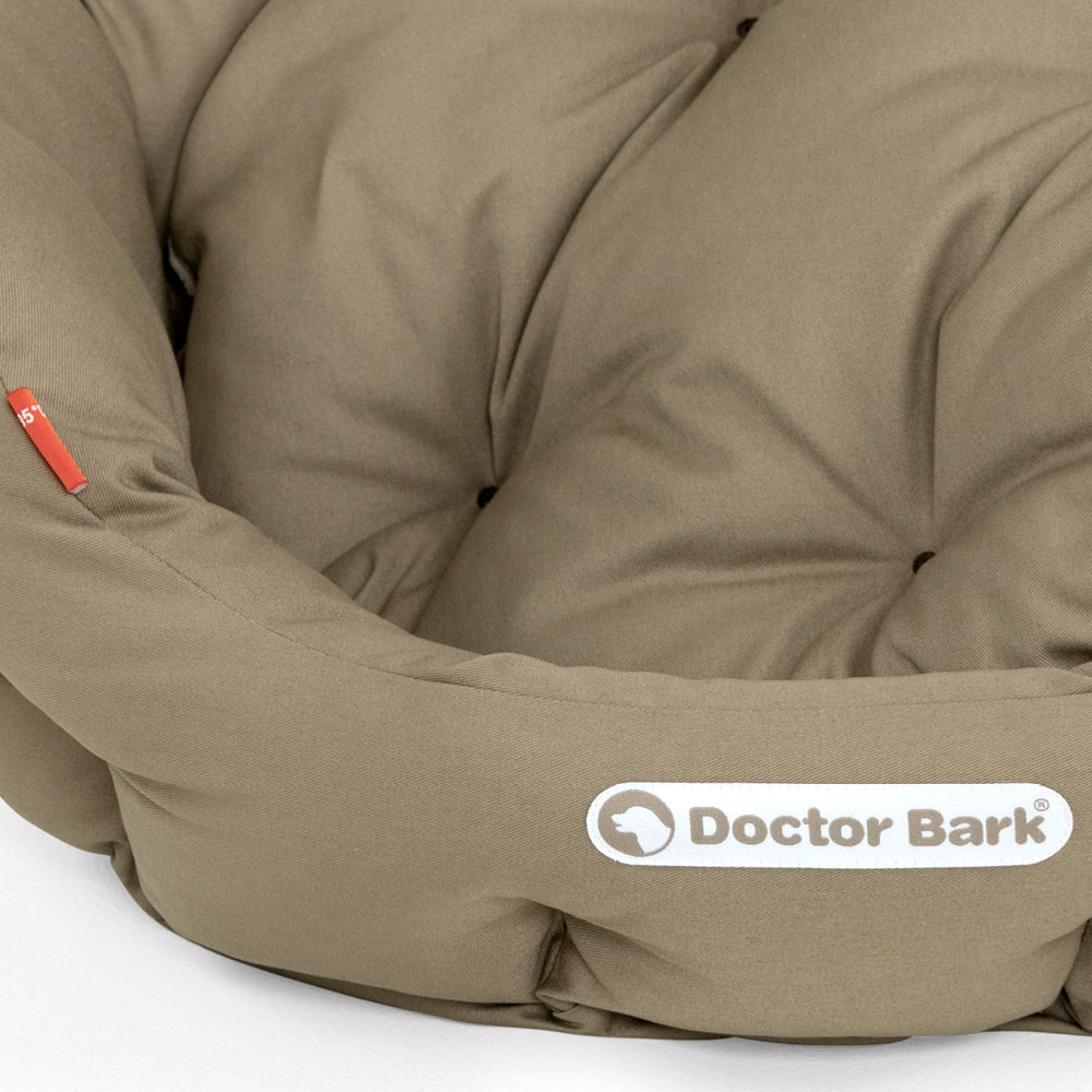 Gepolstertes, rundes Hundebett in warmem Farbton mit weicher Oberfläche und gestepptem Design für optimalen Komfort.