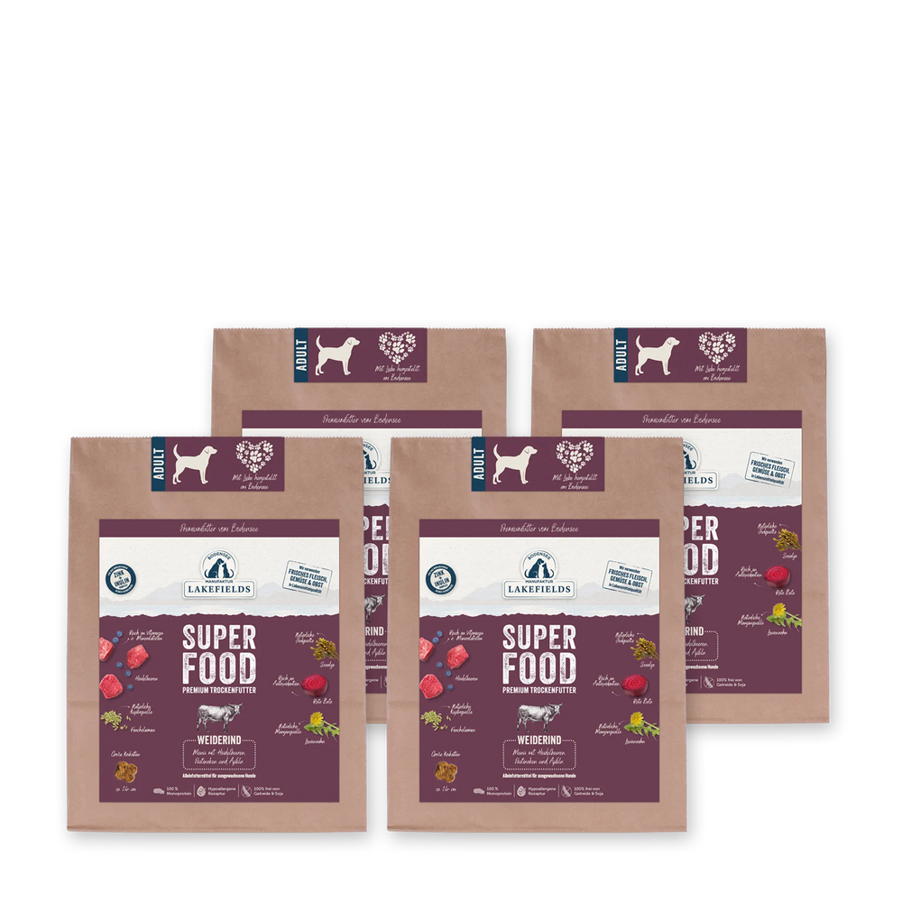 Vier Packungen Lakefields Hundefutter "SUPERFOOD Rind" mit bunten Illustrationen von frischen Zutaten.