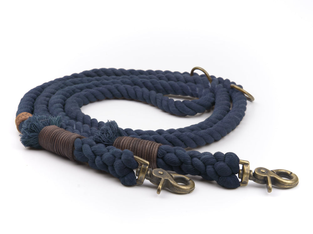 Dunkelblaue geflochtene Tauleine mit Karabiner und braunen Griffwicklungen auf hellem Hintergrund.