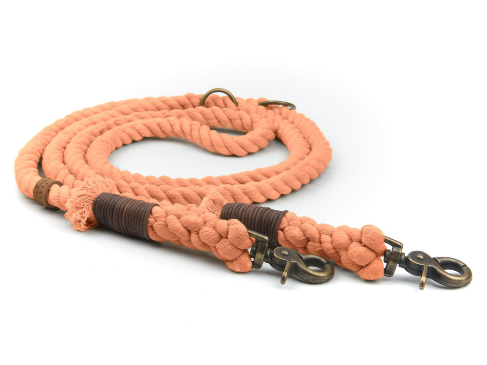 "Orange geflochtene Tauleine mit braunem Griff und zwei metallischen Karabinerhaken für Hunde"