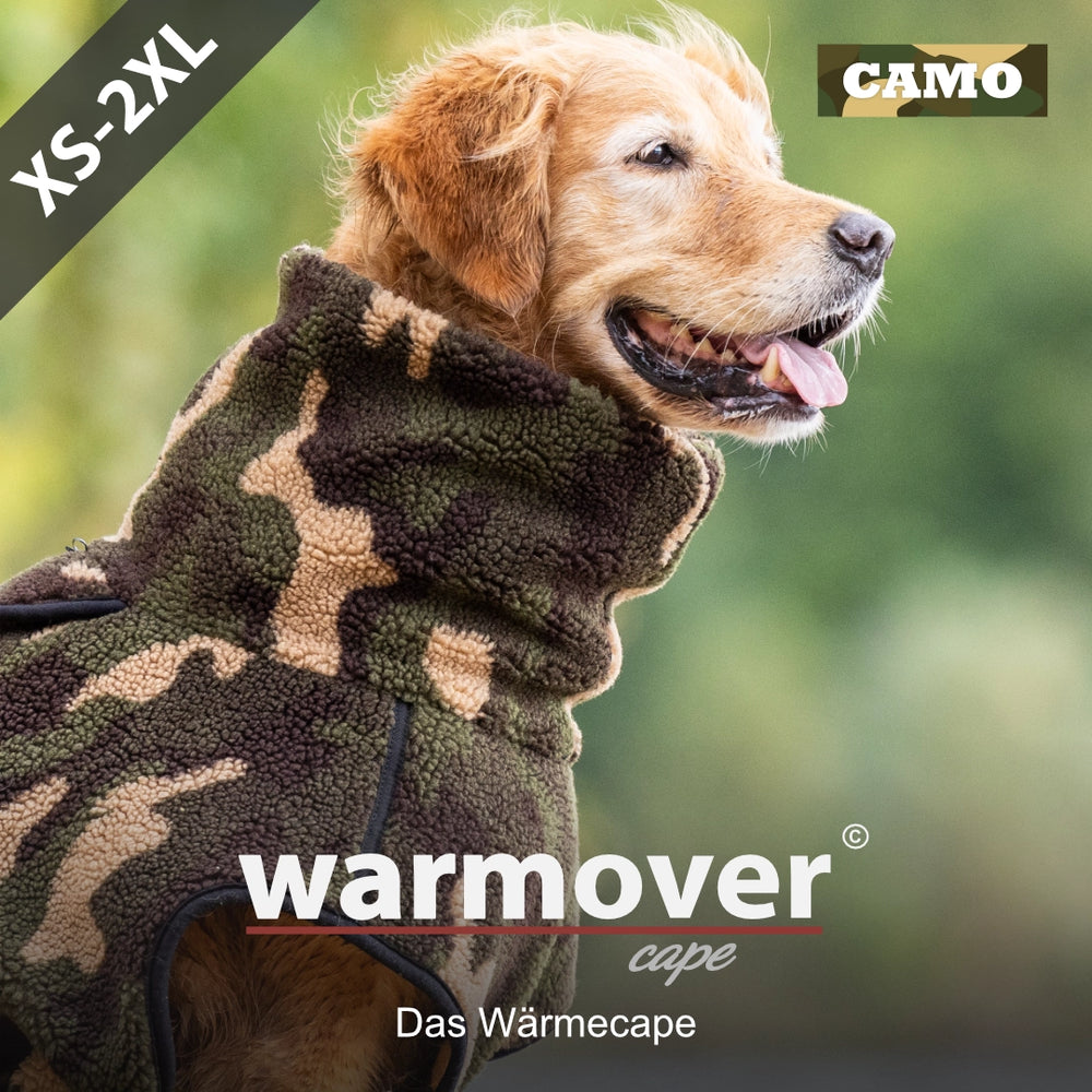 Golden Retriever in camouflagefarbenem Wärmecape für Hunde, Größe XS bis 2XL, im Freien sitzend und lächelnd.