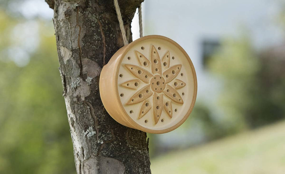 "Handgefertigtes Wildbienenhaus aus Holz mit sternförmigem Muster, ideal für die Förderung von Wildbienen."