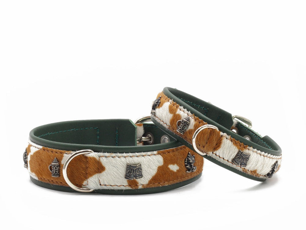 Zwei elegante Hundehalsbänder aus Leder mit Fellmuster in Braun und Weiß, verziert mit silbernen Schnallen und D-Ringen.