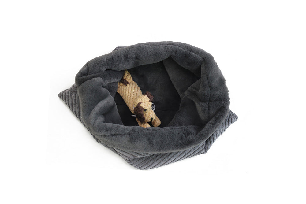 Graues, ovales Hundebett im flauschigen Design mit Hundespielzeug in der Mitte, ideal für Hunde zum Schlafen.