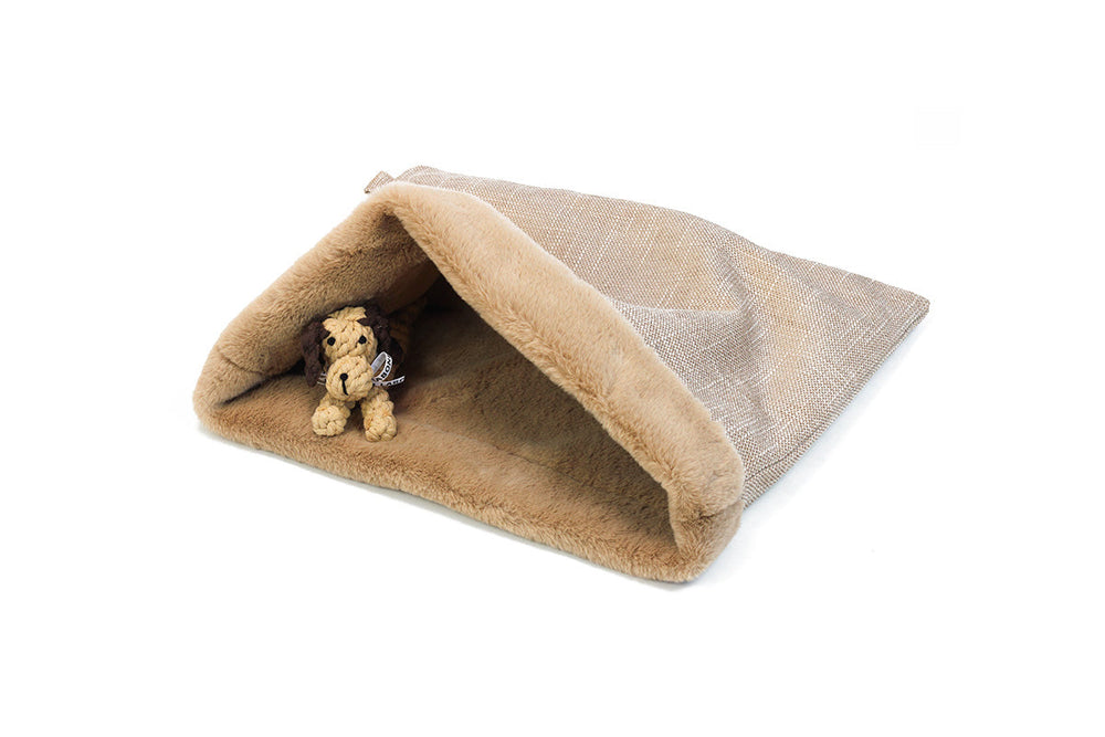 Kuschelhöhle für Hunde in Beige mit weicher Innenauskleidung, darin liegt ein plüschiger Hund entspannt.
