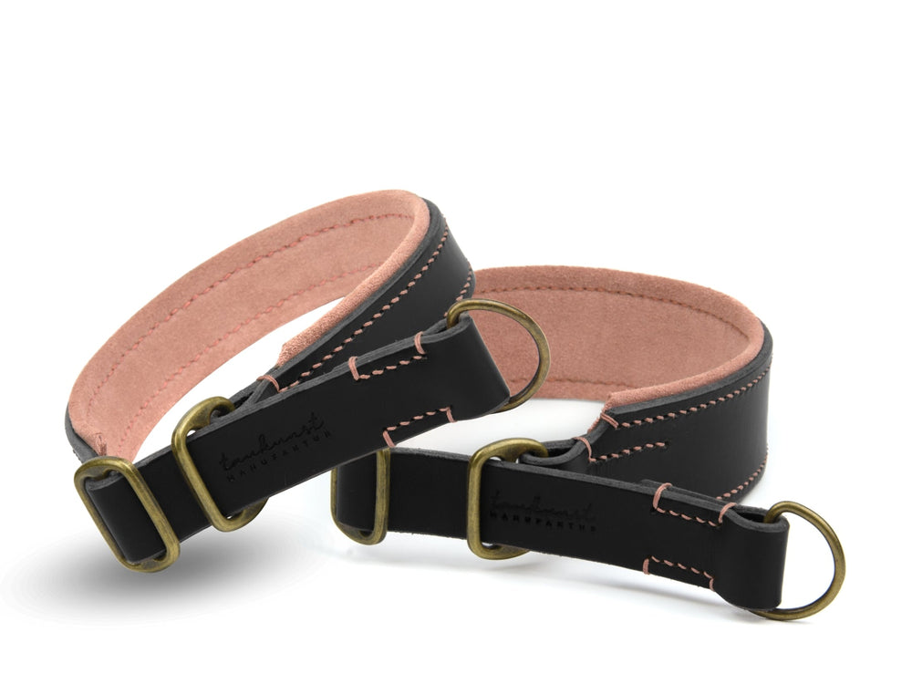Zwei schwarze Lederhalsbänder mit rosa Innenfutter und goldfarbenen Schnallen, schlicht und funktional gestaltet.